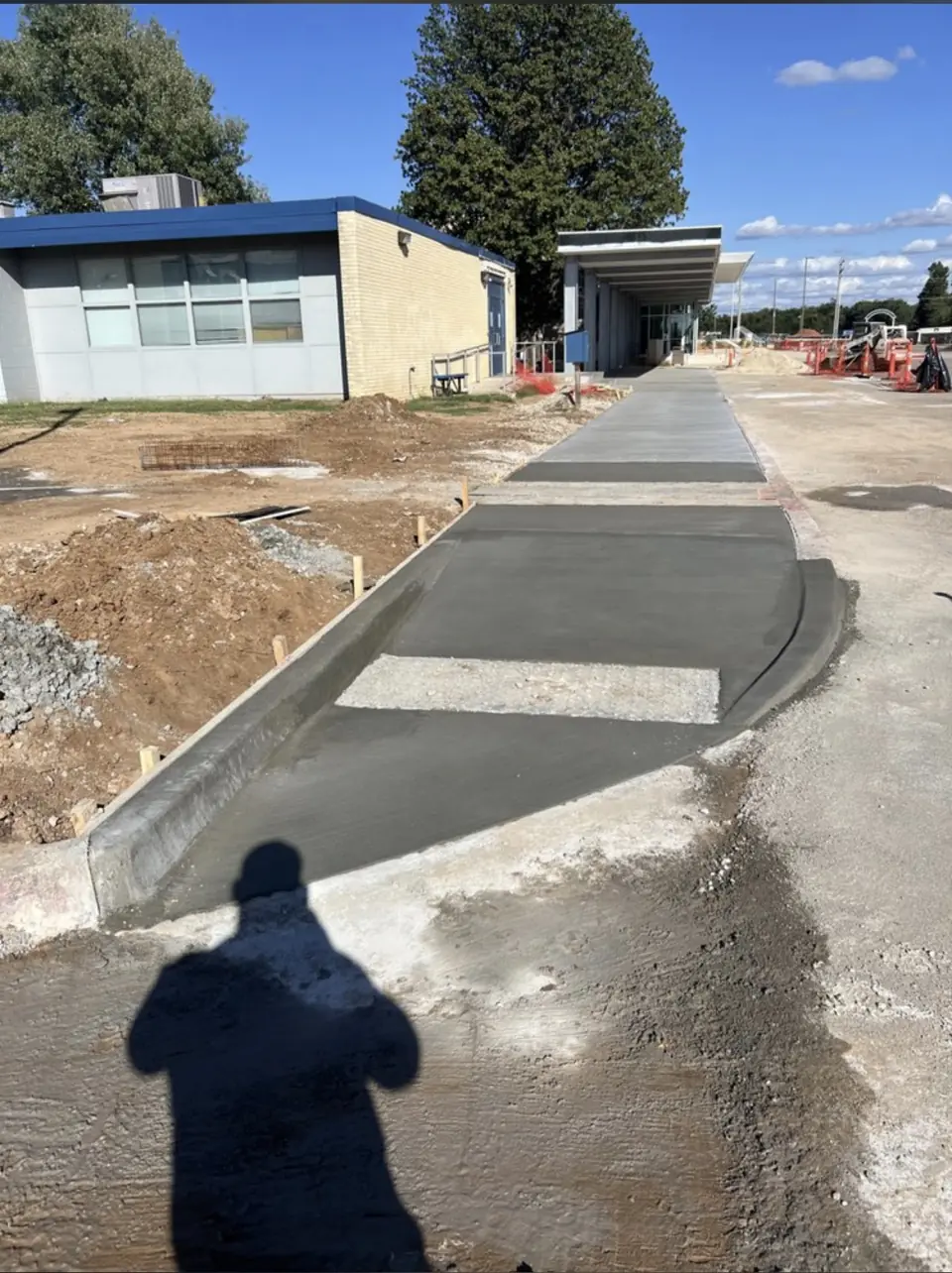 Freshly poured ADA-compliant concrete curb ramp with detectable warning area at Star Spencer High School, Spencer, OK