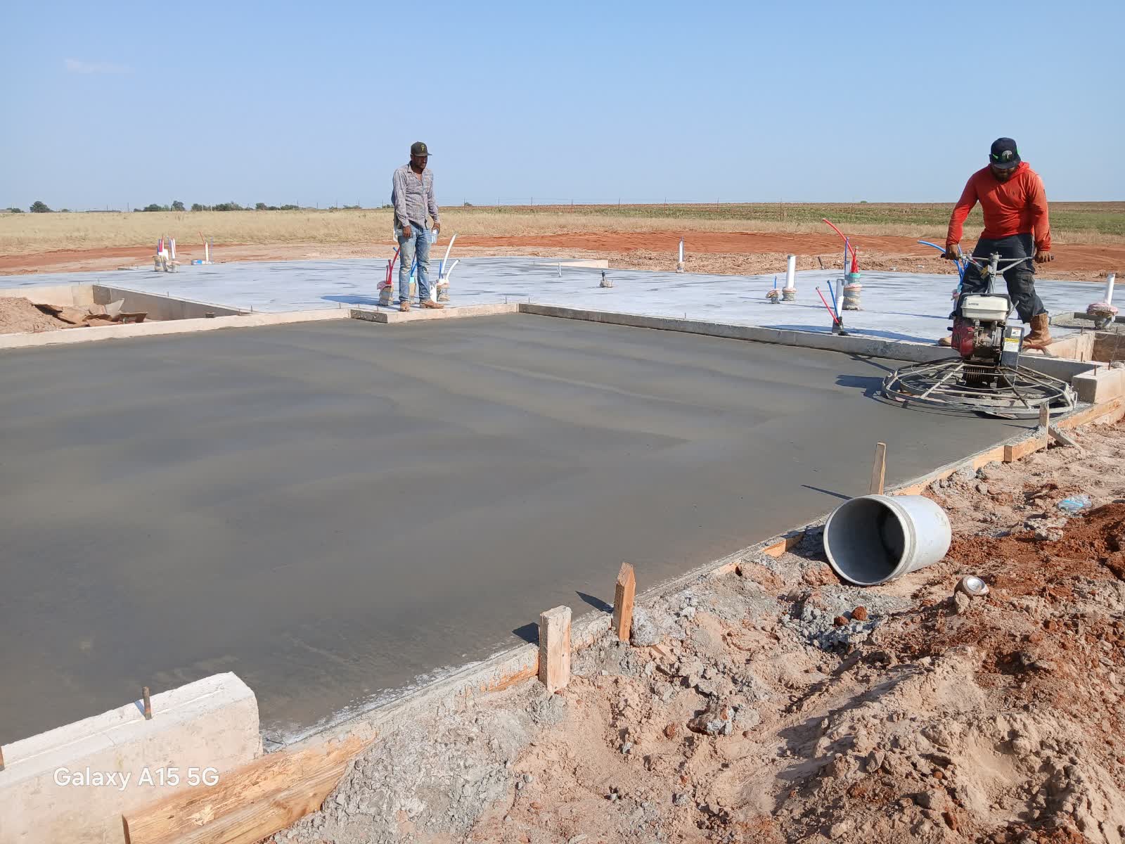 FDZ Construction crew finishing residential foundation slab in Piedmont, OK with power trowel